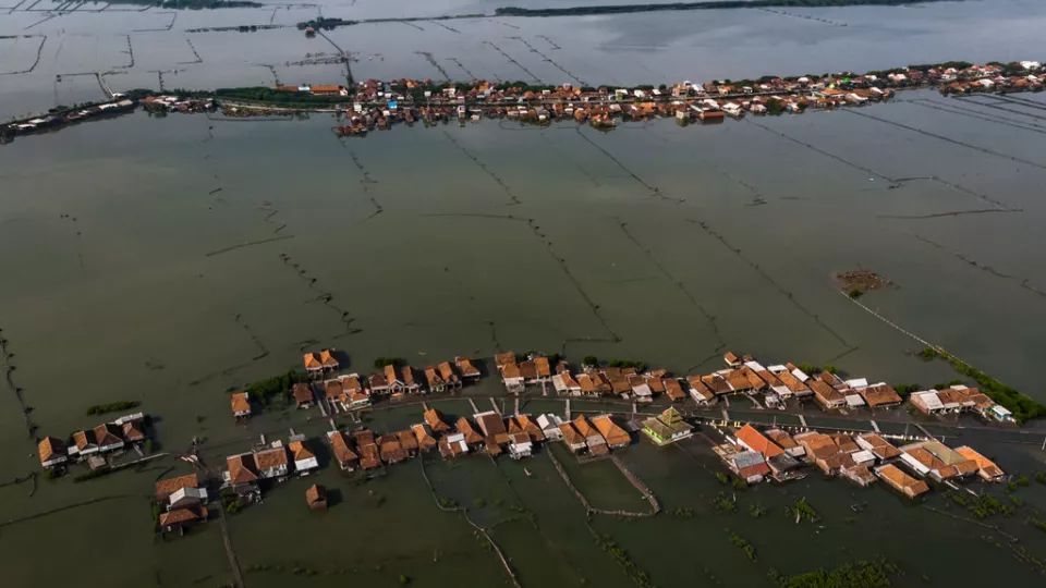 Arial photo of a village in Indonesia surrounded by water due to rising sea levels. 