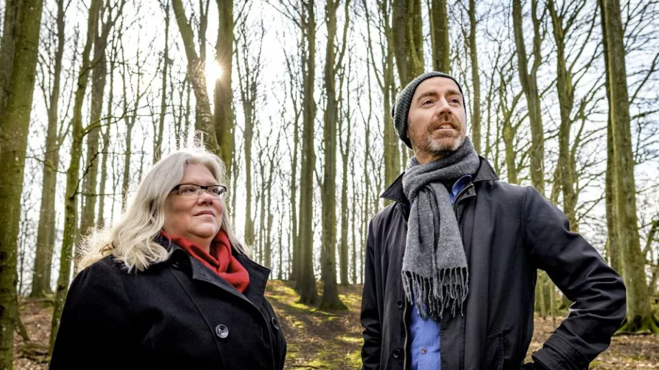 A woman and a man standing in a forest. Photo.