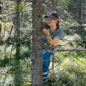 Photo of Emily Register climbing a tree