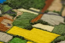 Embroidery of agricultural landscape. Photo.