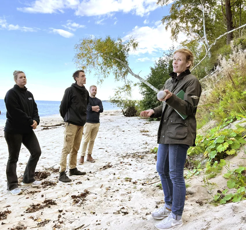 Caroline Hallin and three students standing on the beach. Photo.