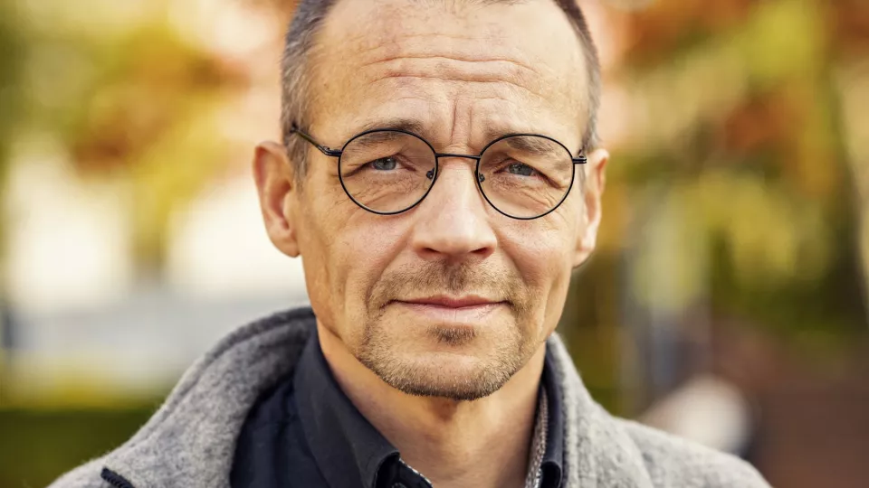 Porträttbild av Markku Rummukainen utomhus i höstfärger. Foto.