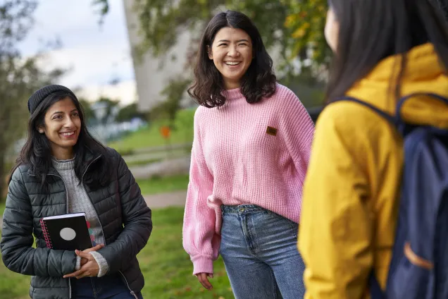 Tre studenter i färgglada kläder. Foto.