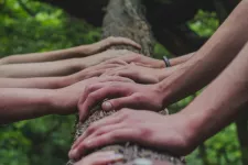 inzoomat bild på många händer på en trädgren
